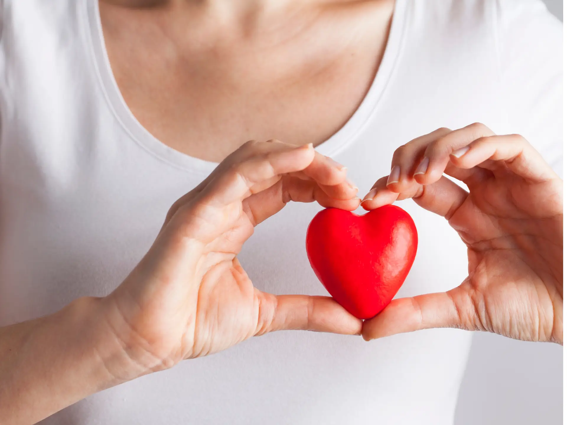 A person holding a red heart-shaped object - best health assessments uk