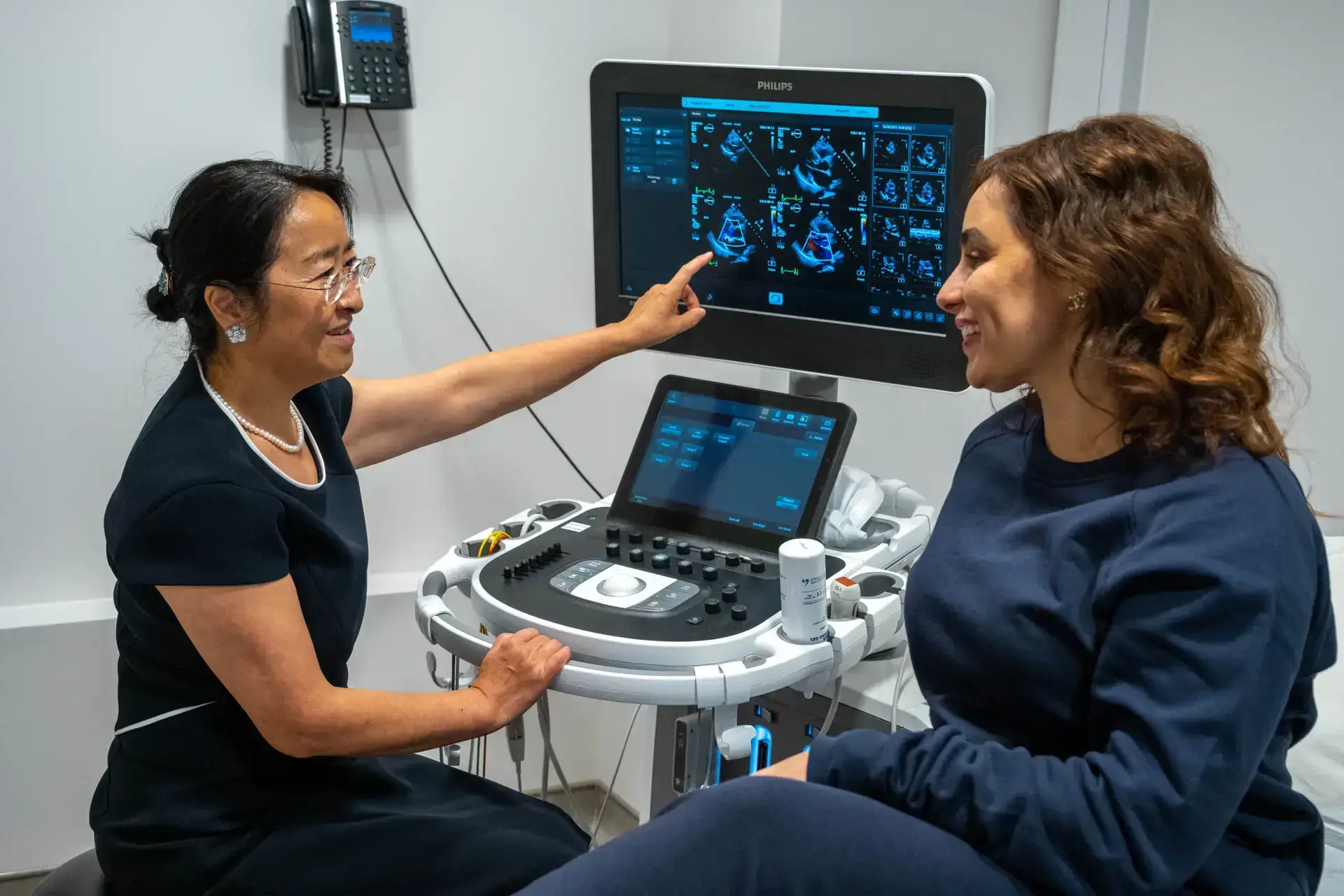 Dr wei li explains ultrasound scan results to a patient