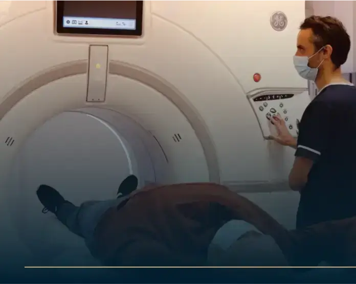 Patient undergoing CTCA scan with medical technician operating CT scanner