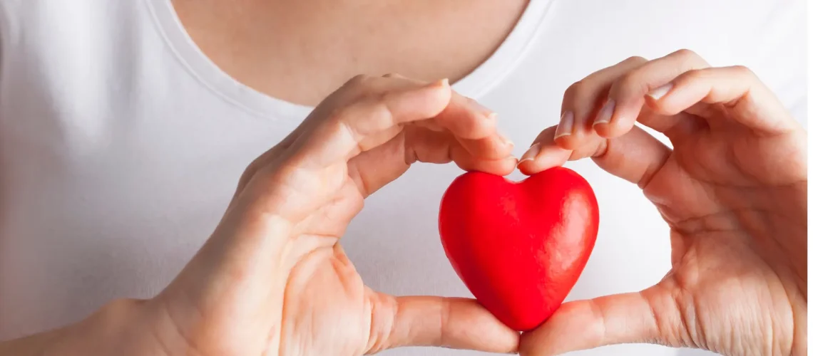 A person holding a red heart-shaped object - best health assessments uk